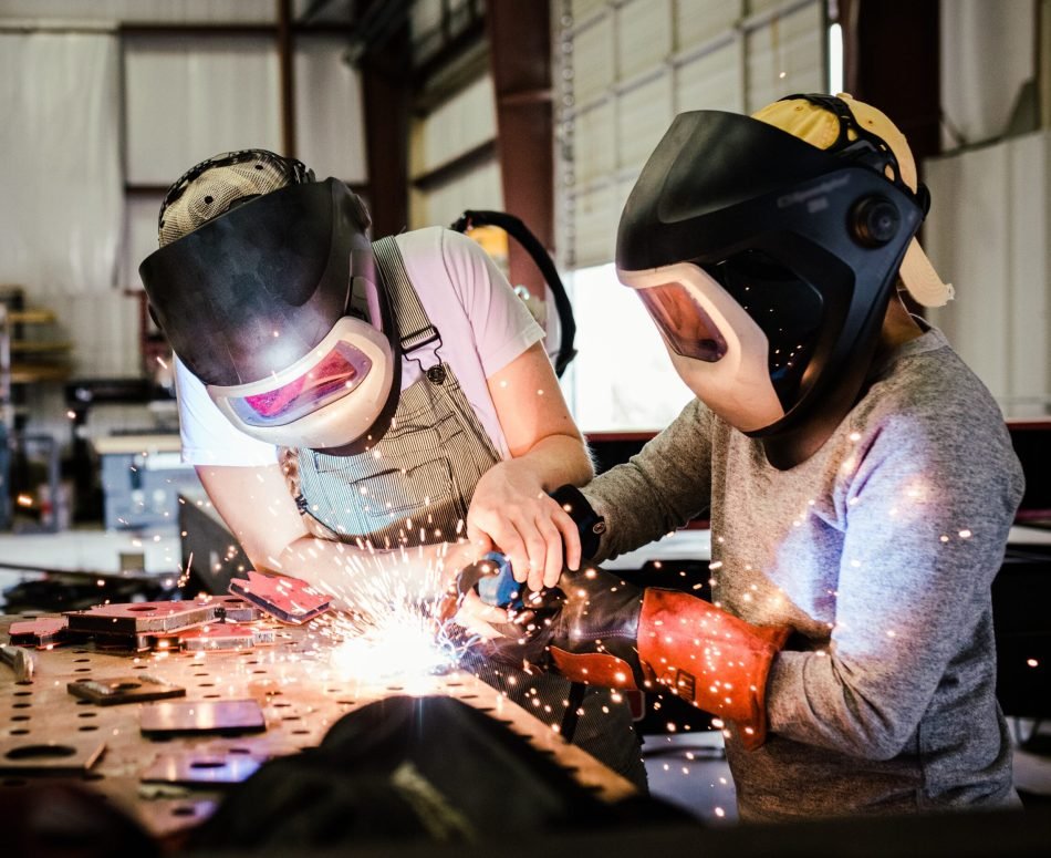 a-female-welder-teaches-a-child-how-to-weld-variou-2023-11-27-05-13-28-utc